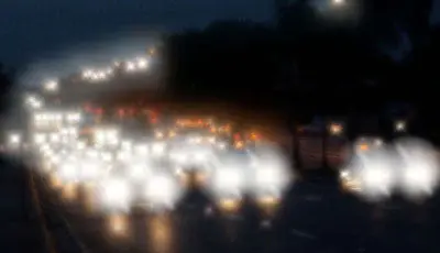 Autobahn in der Nacht. Autos kommen auf den Betrachter zu. Das Bild ist deutlich unscharf und zeigt starke Lichtstreuungen.